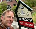 Makelaar van Bruins Makelaardij naast een Te koop-bord